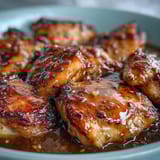 A fork gently lifts saucy slow cooker honey mustard chicken, with fluffy white rice and steamed broccoli alongside.