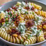 Creamy Mexican street corn elote pasta salad featuring tangy lime dressing, fresh cilantro, and crumbled cotija cheese for a bold side dish.