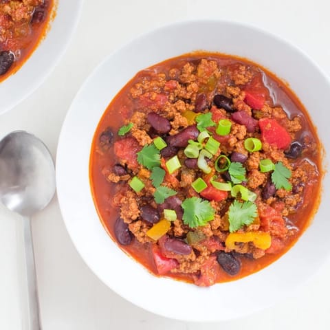 Hearty Turkey Chili simmering in a pot with rich tomato broth, black beans, and tender ground turkey for a cozy meal.