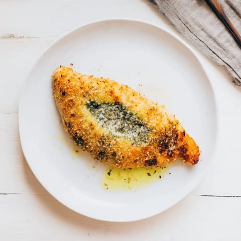 Freshly cooked Mozzarella & Pesto Stuffed Chicken served with roasted vegetables and a garnish of basil leaves.  