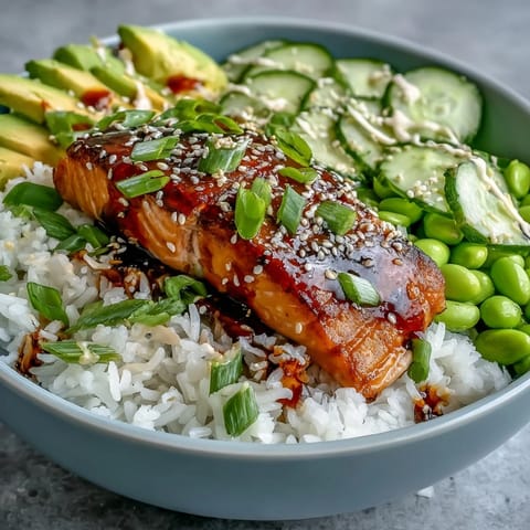 Flaky pan-seared salmon glazed in honey sriracha, nestled on jasmine rice with crisp cucumber slices.