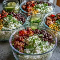Freshly diced red bell peppers and corn top fluffy rice in a vibrant Meal Prep Burrito Bowl Base ready for assembly.