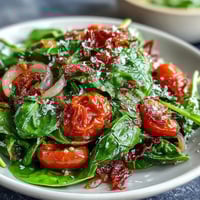 Fresh dandelion greens salad with zesty lemon vinaigrette and Parmesan shavings, a bright Mediterranean-inspired starter.
