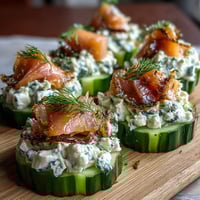 Cucumber Bites with Cream Cheese and Smoked Salmon arranged on a white platter with dill garnish.  